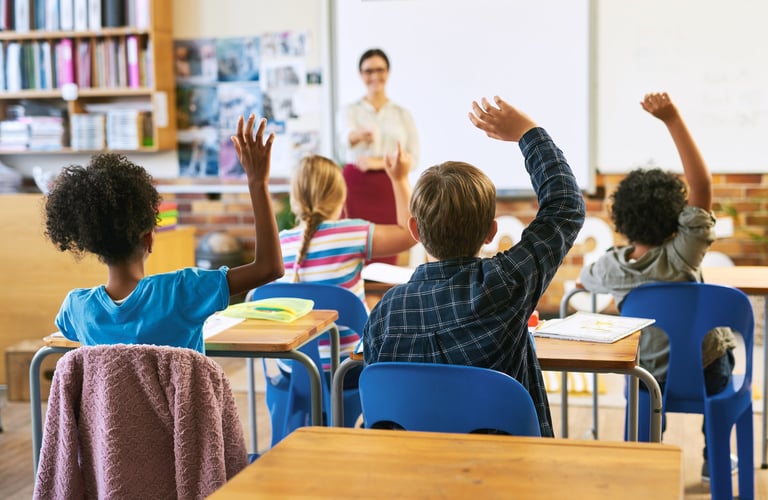 Glückliche Kinder zeigen lachend auf die Kamera