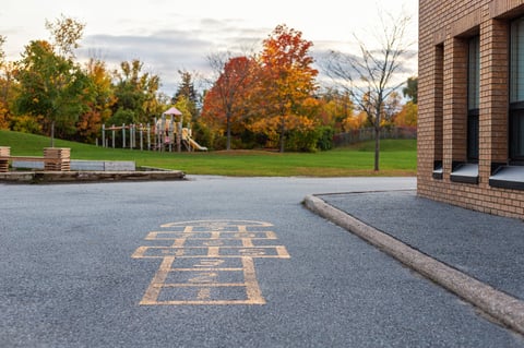 Schulgebaude mit Spielplatz