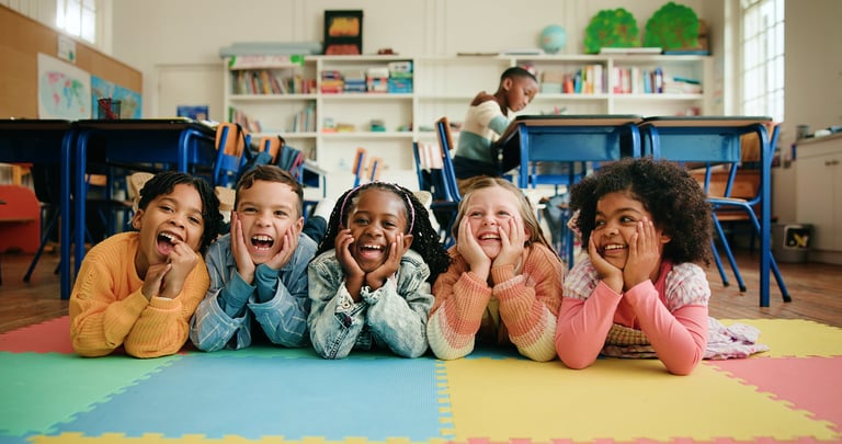 Lachende Kinder in der Klasse, glücklich und voller Freude beim Lernen